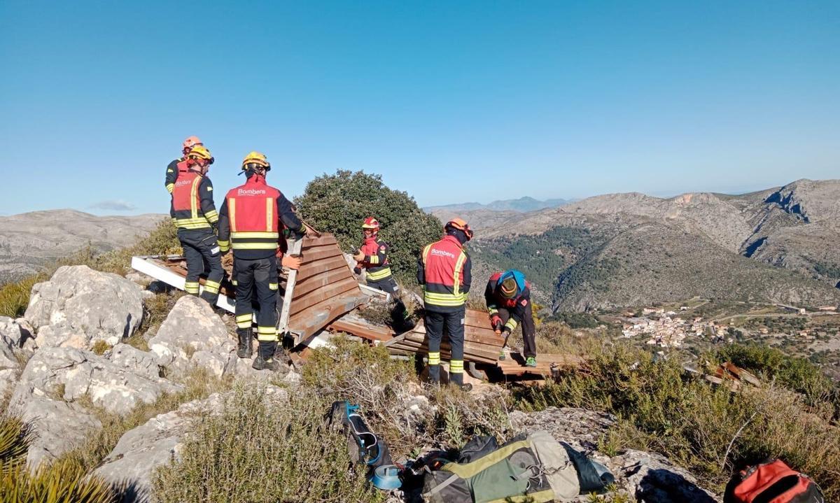 Integrantes de la Associació de Bombers de la Marina Alta retiran la chatarra del repetidor