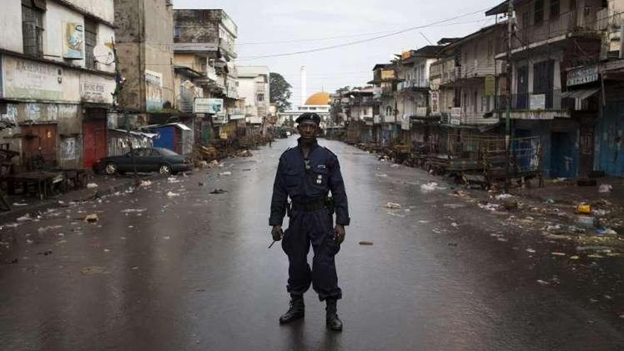 Un policía patrulla en una calle desierta, ayer, en Freetown, capital de Sierra Leona.