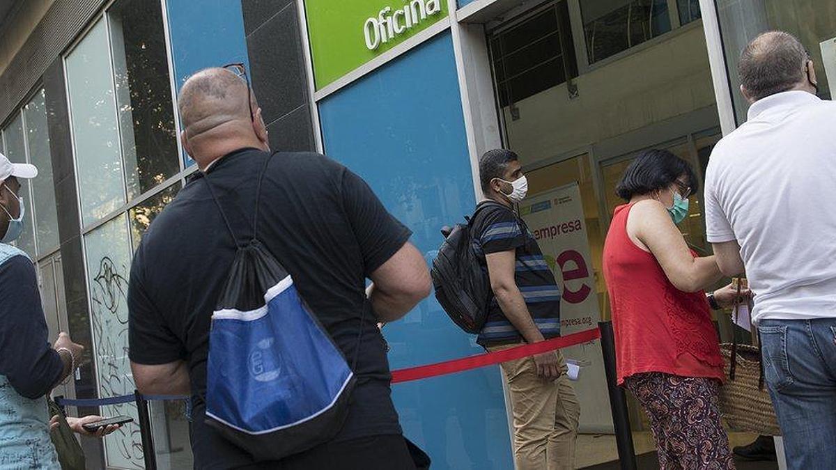 Personas en paro hacen cola frente a una oficina del SEPE en Barcelona para ser atendidos.