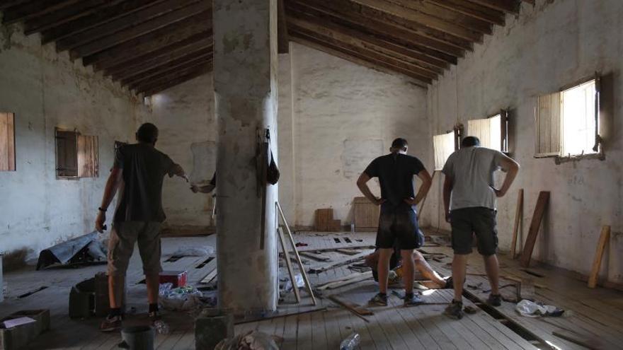 Jovenes impulsores del Ateneo Popular, ayer en plenos trabajos de rehabilitación del antiguo granero que han ocupado.