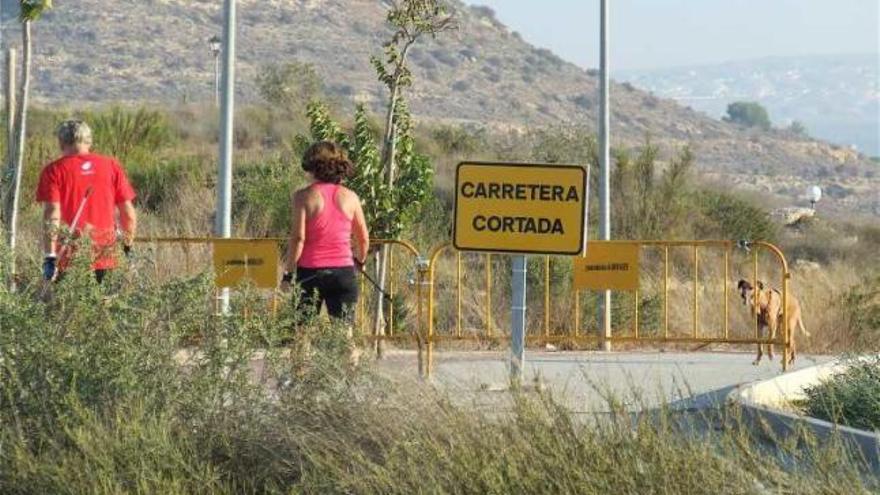 Dos aficionados a la marcha nórdica, junto a un perro suelto.