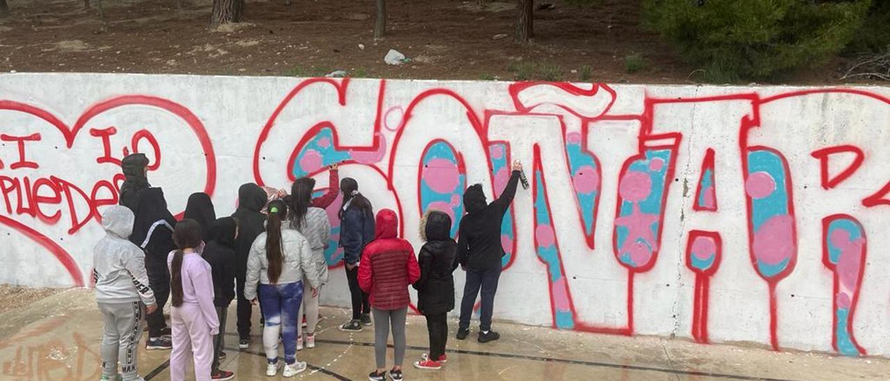 Los alumnos del Miguel Servet de Elda pintando el grafiti junto a Dolar One.