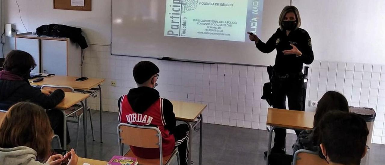 Oficial de la Policía Nacional impartiendo una charla de prevención sobre el uso del móvil en un aula de Elche. | INFORMACIÓN