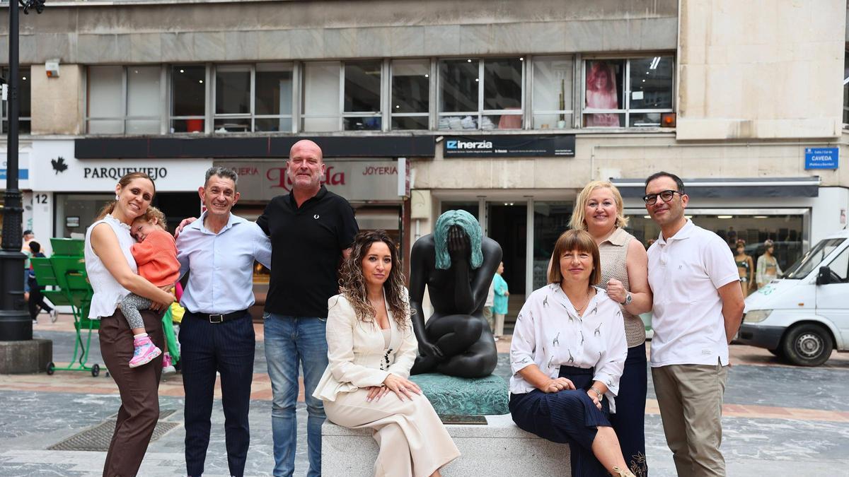 Por la izquierda los comerciantes Ana Pérez, con su hija Ana Sofía Figueroa, Alberto Camero, José Luis Sánchez, Patricia Miranda, María José Fernández, Nieves Ania y Pelayo Gutiérrez junto a la estatua de «Mavi».