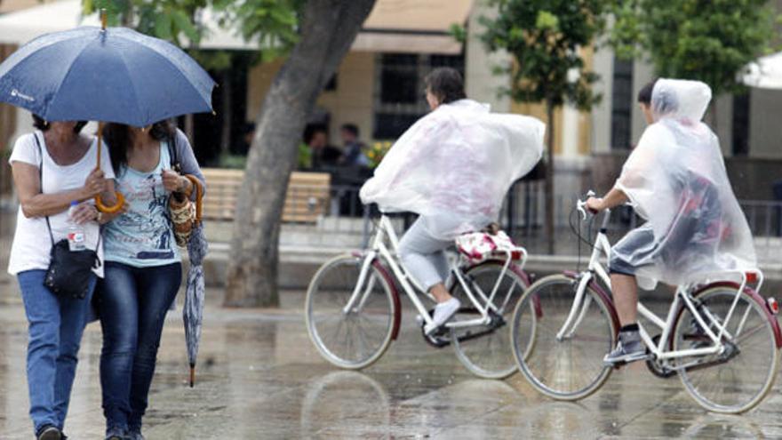 Ciudadanos caminando bajo la lluvia en la capital.