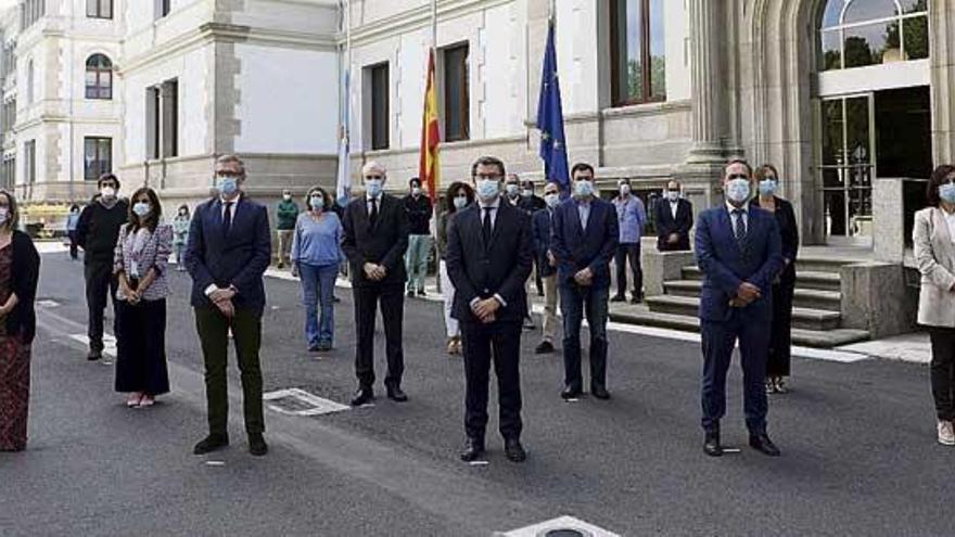 Miembros del Gobierno gallego y funcionarios, durante el minuto de silencio de ayer.