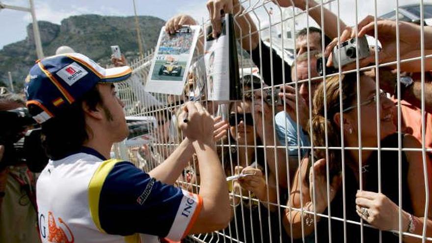 Fernando Alonso firma autógrafos en Mónaco.