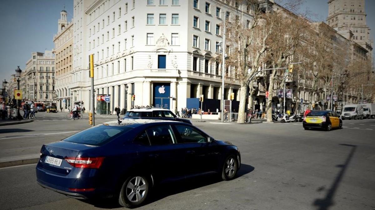 Un vehículo VTC circula por plaza de Catalunya de Barcelona.