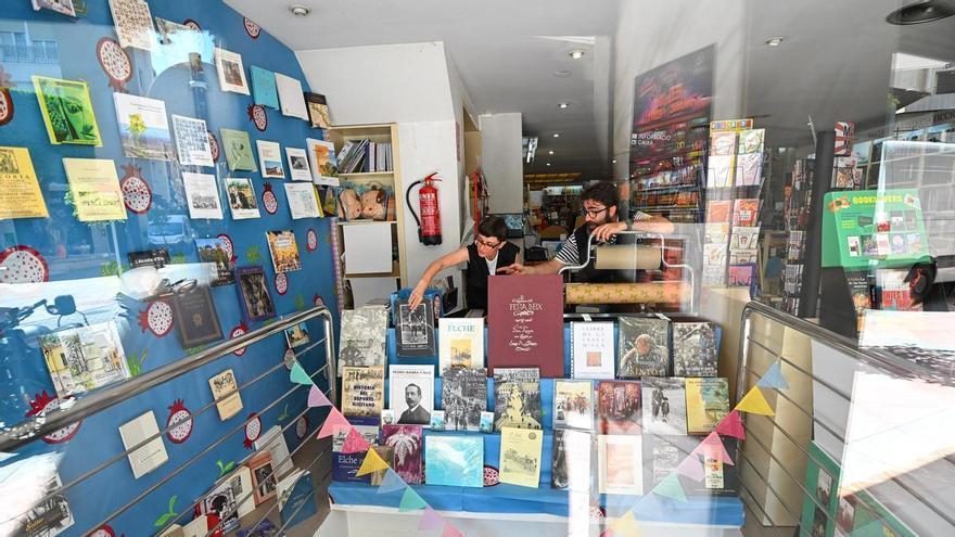 La librería Ali i Truc de Elche dedica un escaparate a libros locales con motivo de las Fiestas de agosto