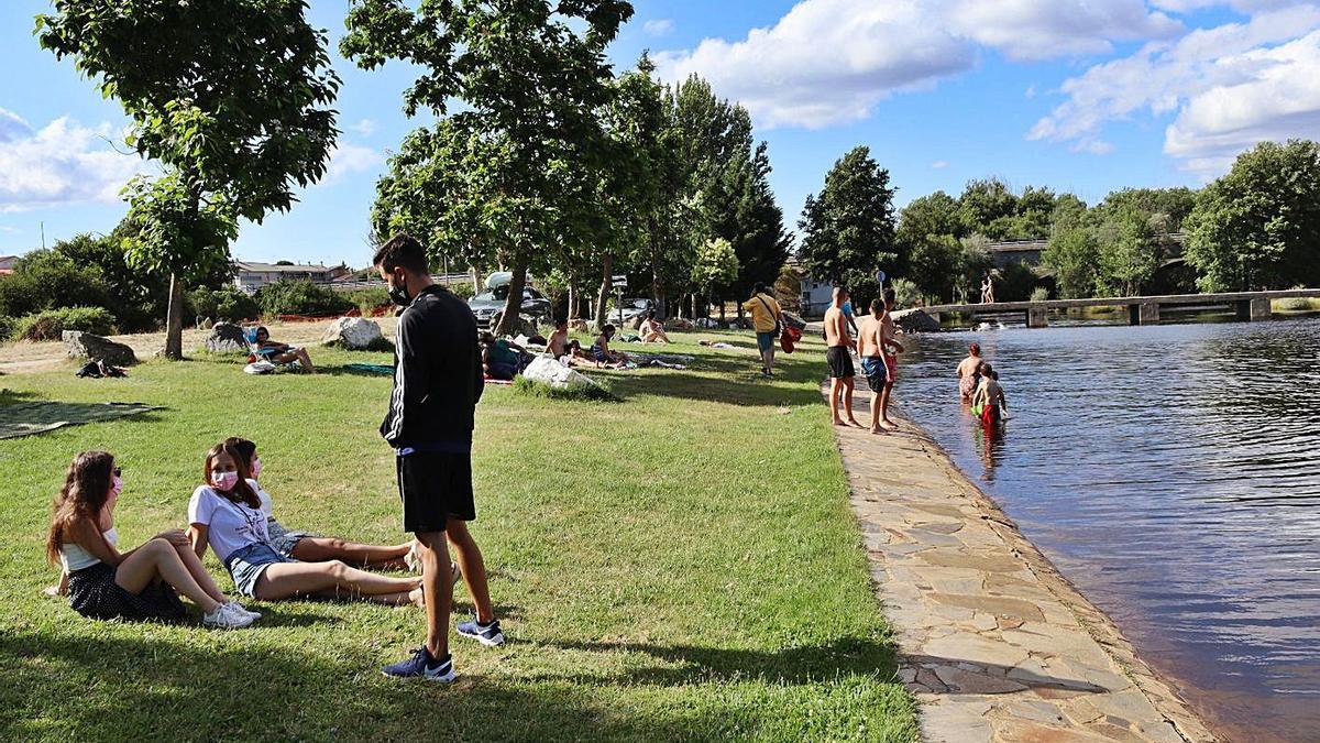 Varios bañistas disfrutan de la playa fluvial de Rionegro del Puente. | A.H.M.