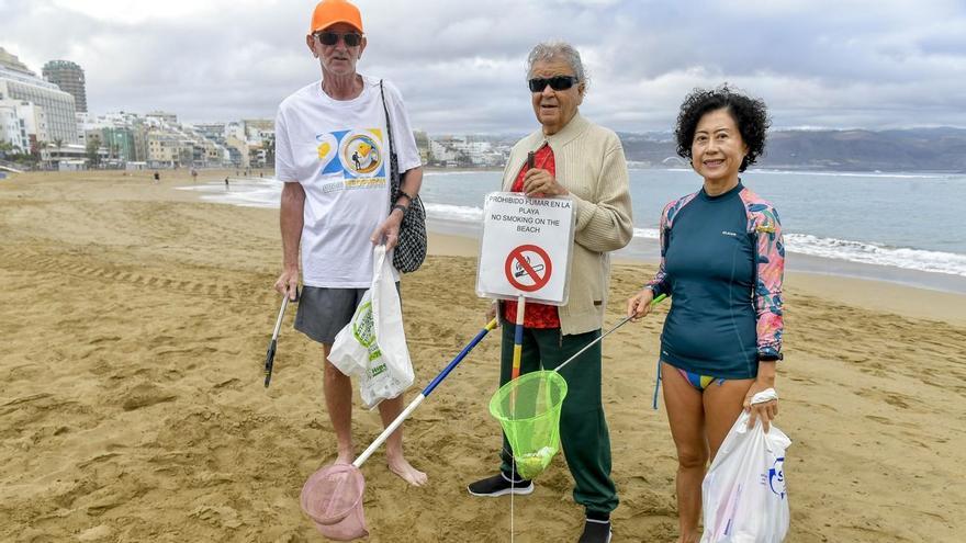 Tres voluntarios limpian diariamente la playa de Las Canteras