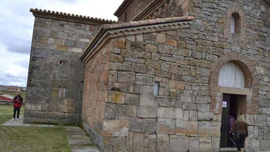 Dos turistas en los alrededores del templo de San Pedro de la Nave.