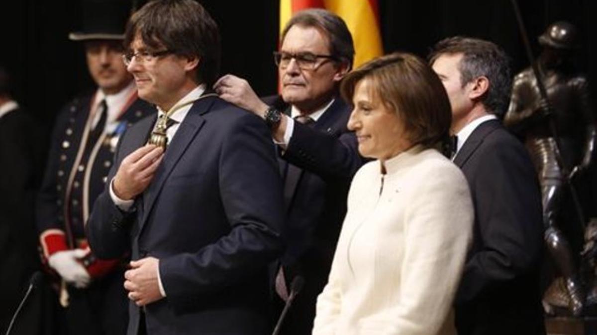 Carles Puigdemont, en su toma posesión como 'president', junto a su antecesor, Artur Mas, y la expresidenta del Parlament, Carme Forcadell, el 12 de enero del 2016.