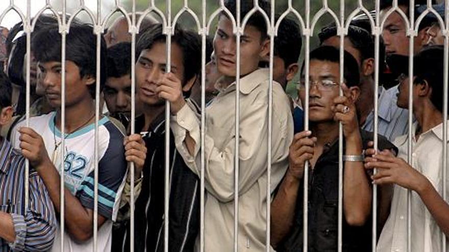 Personas esperan detrás de la puerta del palacio real de Narayanhiti antes del comienzo de la primera y última rueda de prensa del depuesto rey de Nepal, Gyanendra Shahen, en este palacio real de Katmandú, Nepal.