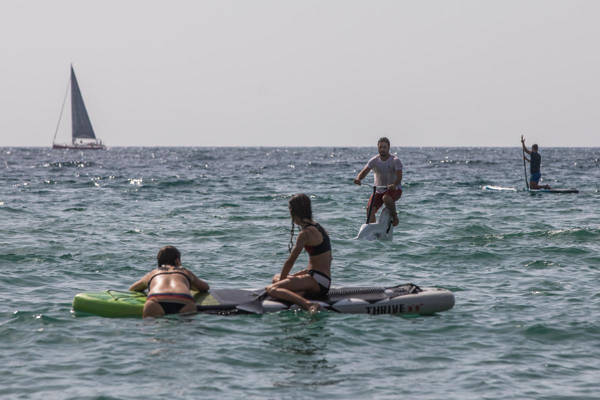 Oriol navega con la hidrobici entre tablas de paddle surf.