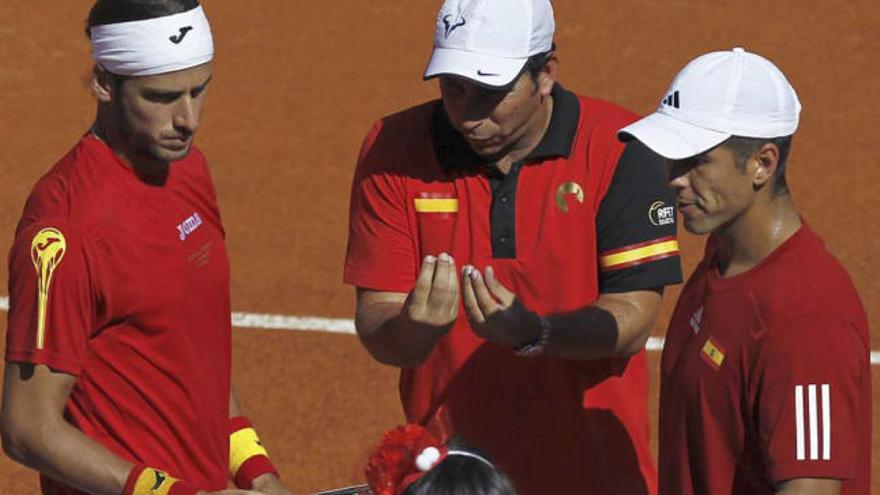 El capitán del equipo español, Albert Costa, da instrucciones a López y Verdasco, erráticos ayer.