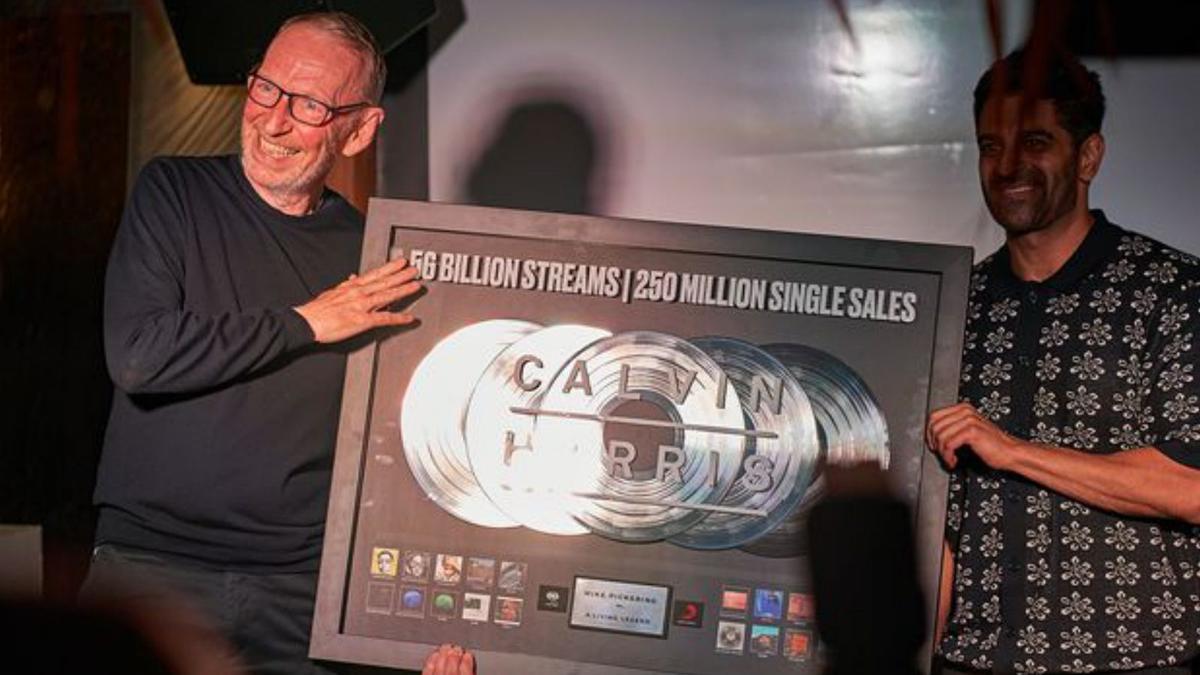 Dipesh Parmar, presidente de Columbia Records UK, entrega el disco conmemorativo de los 250 millones de singles vendidos por Calvin Harris. 