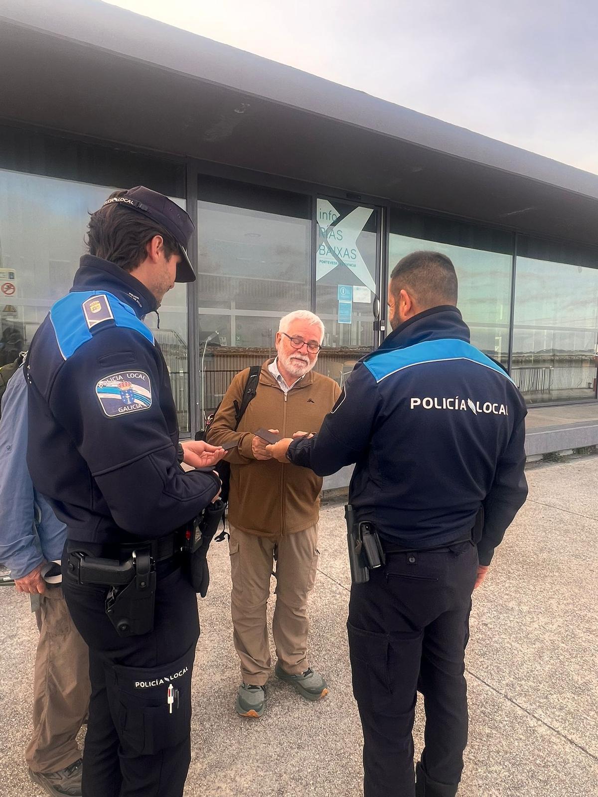 Dos agentes de la Policía Local de Vilanova entregan la cartera y la documentación al ciudadano australiano.