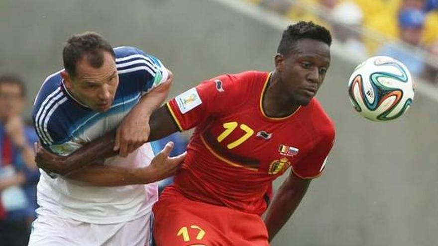 Divock Origi protege el balón ante el ruso Sergey Ignashevich, ayer, en Río de Janeiro.