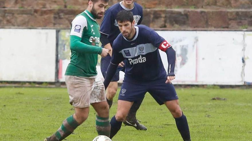 Pablo Hernández disputa un balón ante el Llanes con Trabanco, también lesionado, atento detrás.