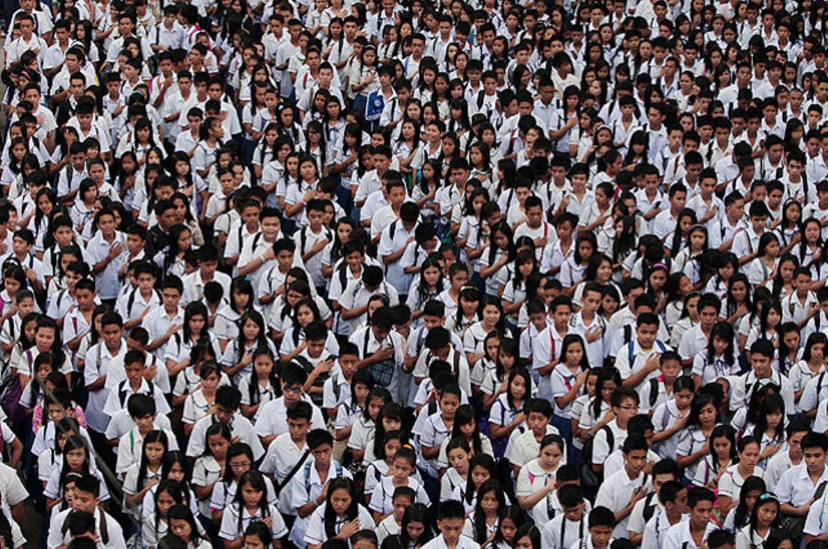 Estudiants filipins, durant la cerimònia del primer dia de classe en un col·legi de Quezon, al nord de Manila. Més de 21 milions d’alumnes que tornen a les escoles del país, s’enfronta amb problemes de superpoblació i falta d’espai a les aules.