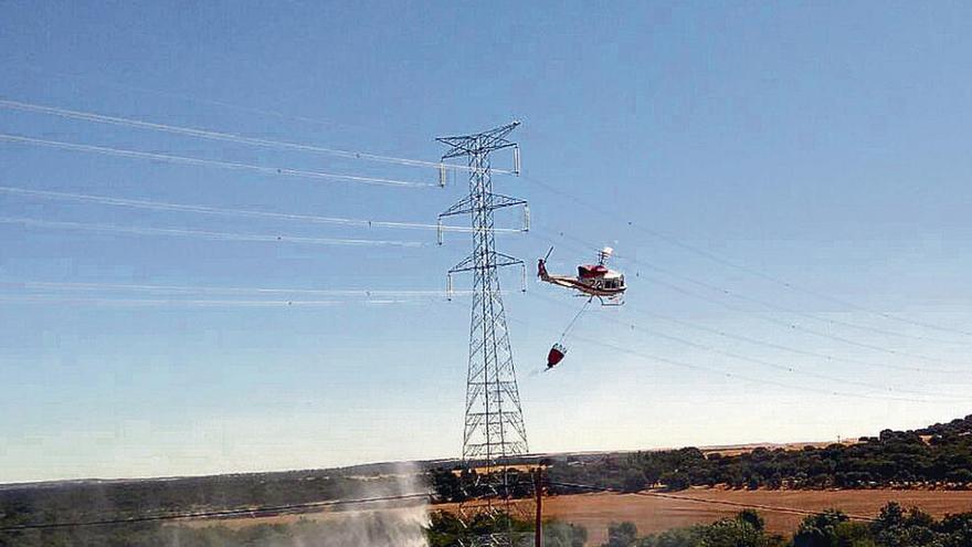 Un helicóptero descarga agua en el fuego de Moreruela, ayer.