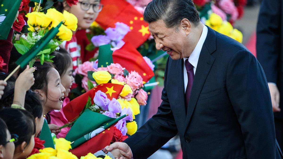 TOPSHOT - China’s President Xi Jinping (R) shakes hands with a girl as she and other children welcome Xi upon his arrival at Macau’s international airport in Macau on December 18, 2019, ahead of celebrations for the 20th anniversary of the handover from Portugal to China. - Chinese president Xi Jinping landed in Macau on December 18 as the city prepares to mark 20 years since the former Portuguese colony was returned, a celebration that stands in stark contrast to months of unrest in neighbouring Hong Kong. (Photo by ANTHONY WALLACE / AFP)