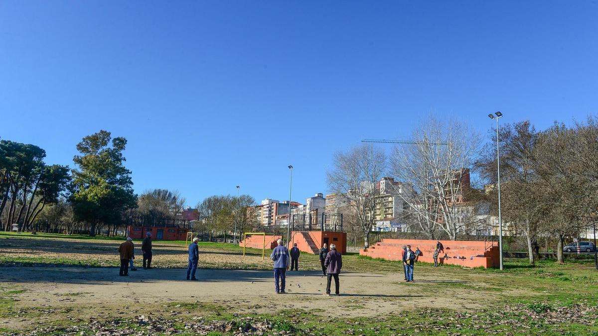 Jugando a la petanca junto al campo donde está previsto ubicar la pista de skate, con los bloques, enfrente.