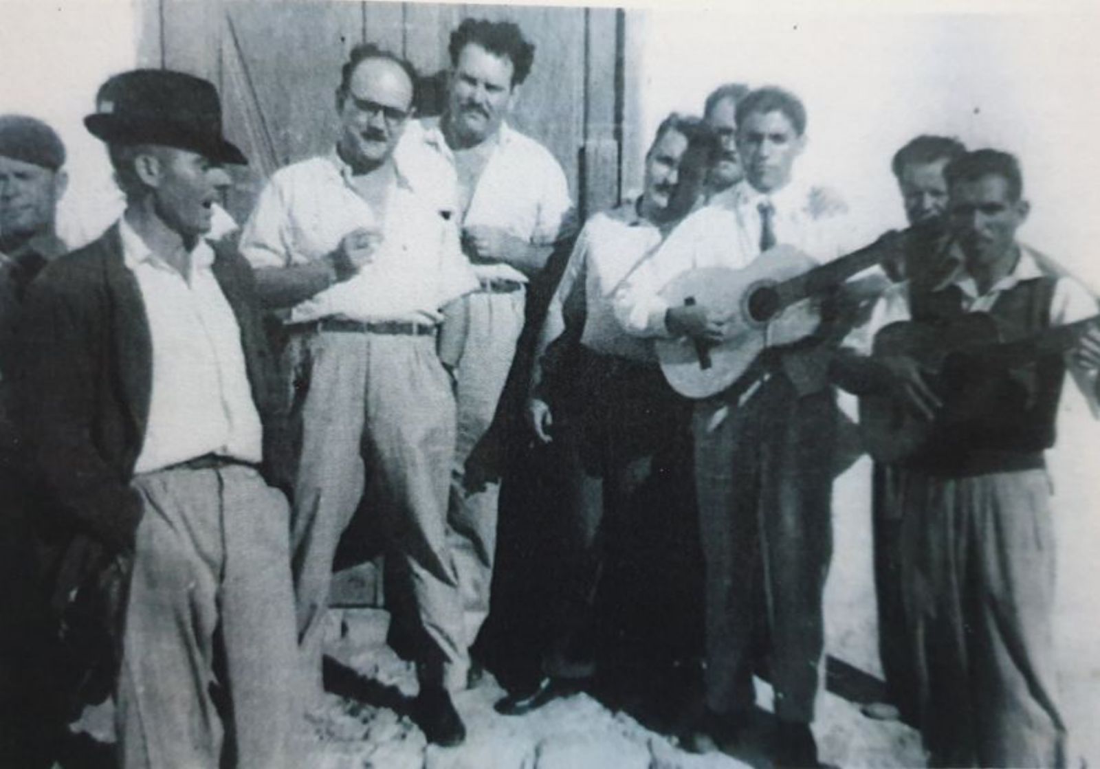 Casimiro Camacho, con corbata, tocando la guitarra. 