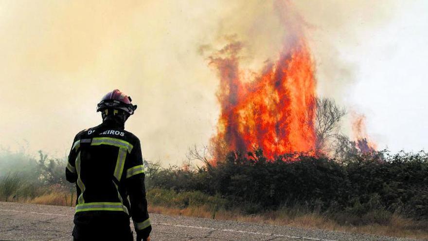 Un bombero,  en las tareas  de extinción  del incendio  de A Cañiza. |   // ANXO GUTIÉRREZ