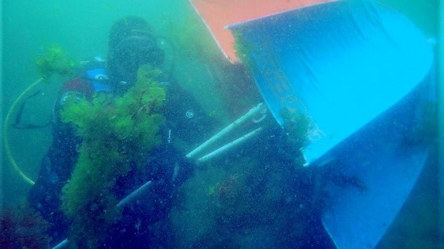 Un buceador retira una sombrilla del fondo marino de las Islas Cíes. // I.B.