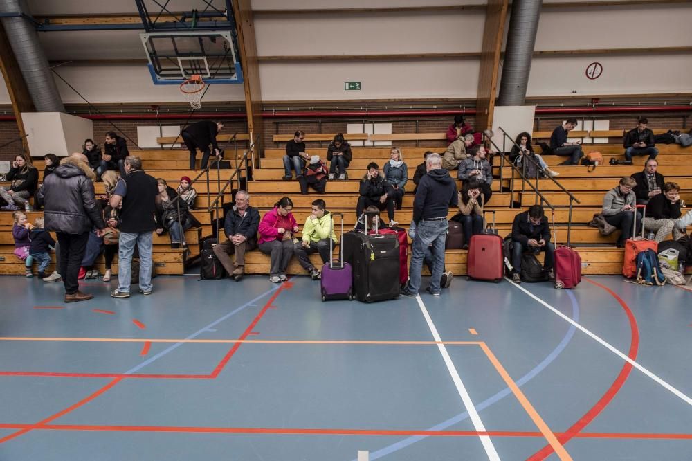 Varios pasajeros descansan en un polideportivo en Zaventem, cerca de Bruselas