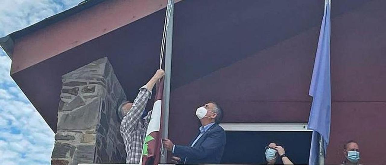 El alcalde, José Valledor, coloca la bandera en el mástil con la ayuda de Manuel Calvo. | Reproducción de D. Á.