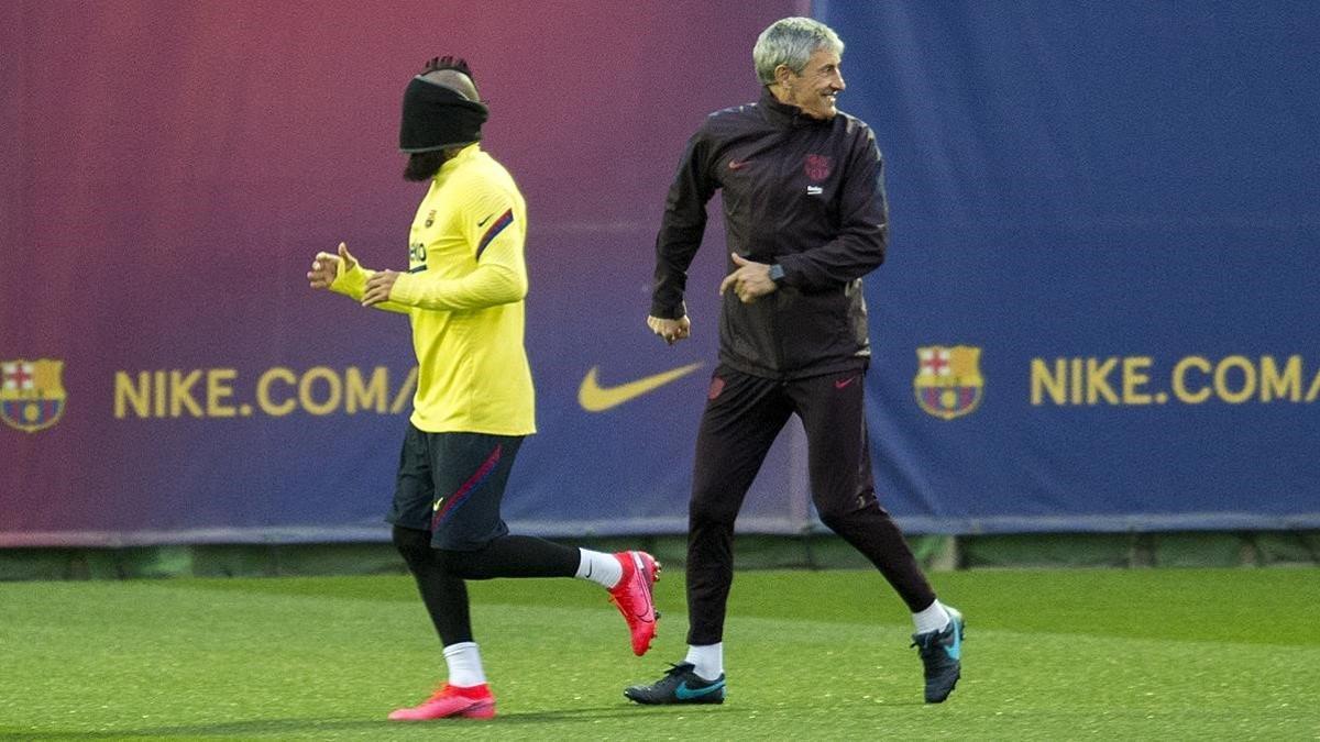 Quique Setien detras de Arturo Vidal que corre con la vista tapada  durante un ejercicio previo al entrenamiento