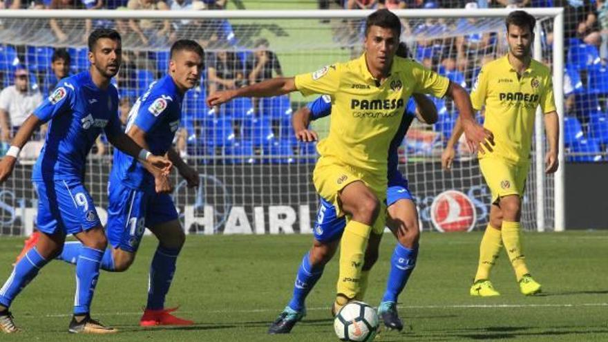 Rodrigo controla el esférico ante la presión de dos jugadores del Getafe.