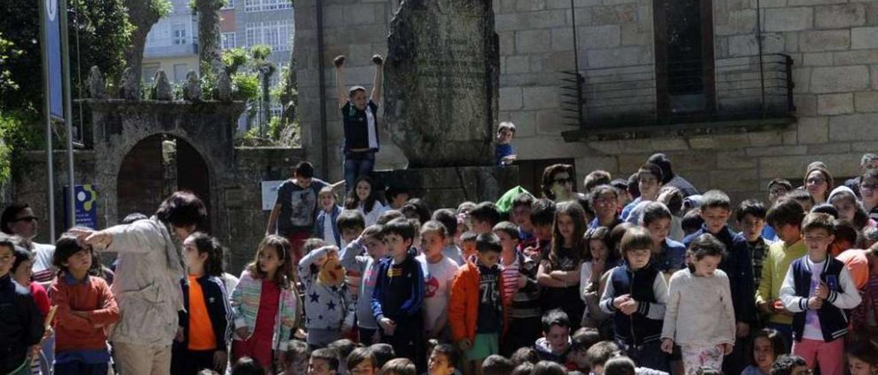 Los niños se reunieron para la ofrenda ante el monumento a Cabanillas de A Calzada. // Noé Parga