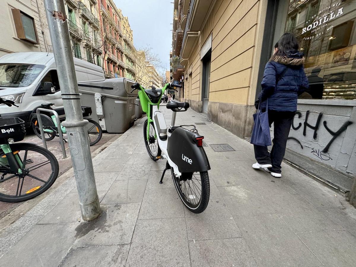 Bicicleta de Lime, en plena acera, en una calle de Gràcia