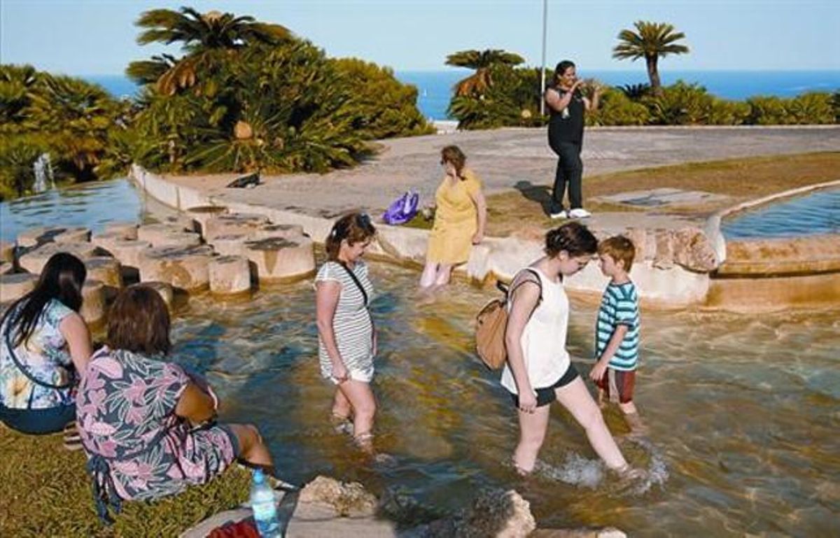 Uns turistes es refresquen a les fonts dels Jardins del Mirador a Montjuïc. Uns turistes es refresquen a les fonts dels Jardins del Mirador a Montjuïc.