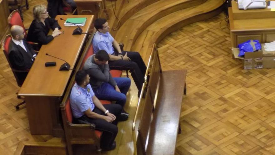 Assegut entre dos mossos, Albert C., plorant ahir, just després d&#039;escoltar la seva absolució