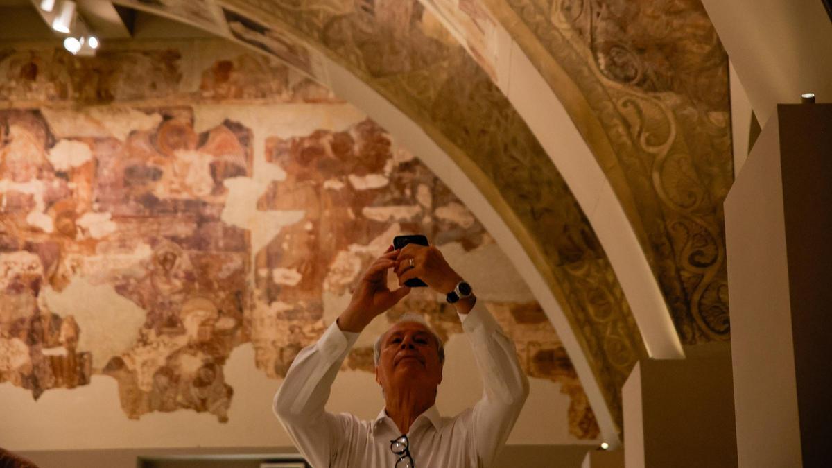 Un hombre fotografía las pinturas murales del Monasterio de Sijena expuestas en el Museu Nacional d’Art de Catalunya (MNAC)