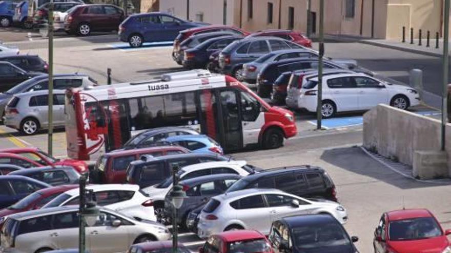 El autobús transitando por las proximidades de los juzgados entre aparcamientos llenos de coches.