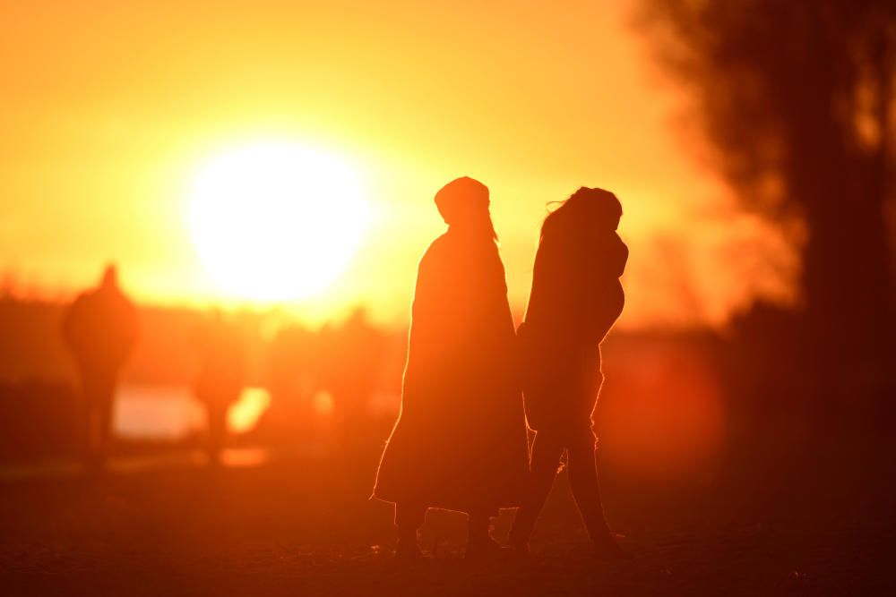 People enjoy the sunset at the Elbe river in ...