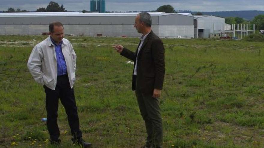 El teniente de alcalde y el regidor de Curtis, en la parcela del polígono en la que se ubicará la planta. / l. o.