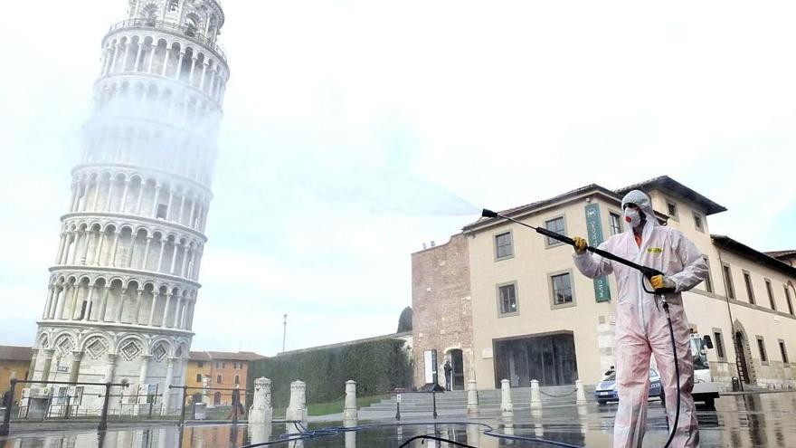 Una persona realiza labores de desinfección en la plaza del Duomo de Pisa, con la torre al fondo. | AGENCIAS