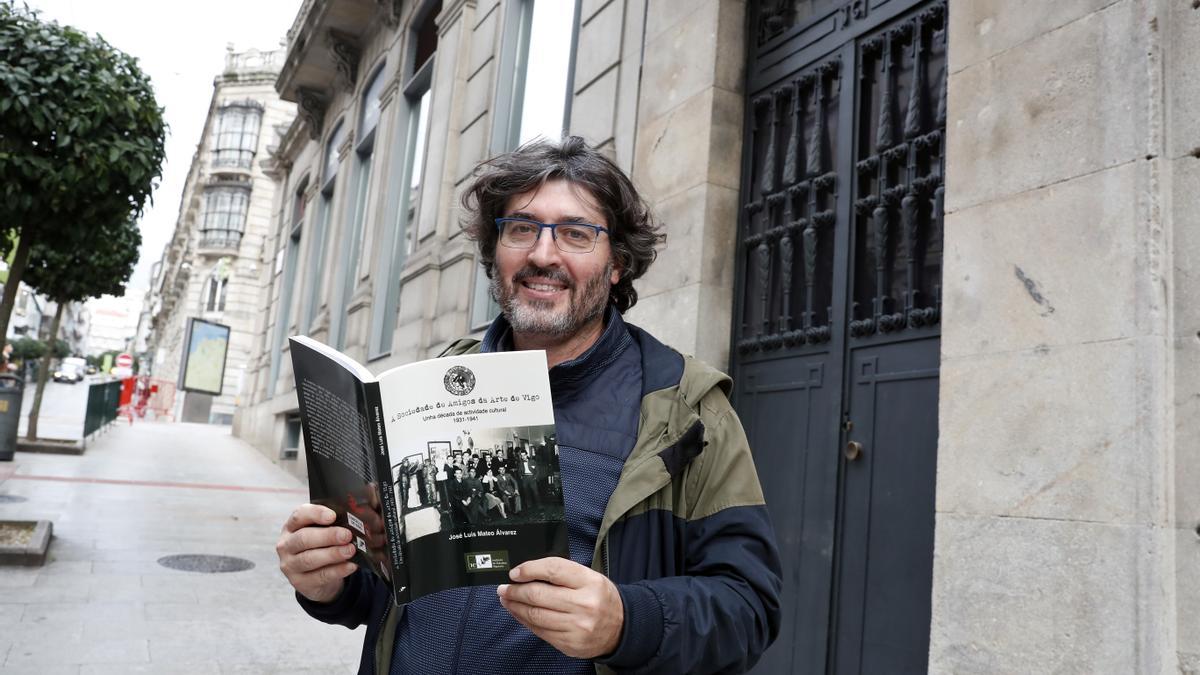 El historiador José Luis Mateo con su libro frente a la puerta de la que en su momento fue sede de la Sociedade Amigos da Arte.