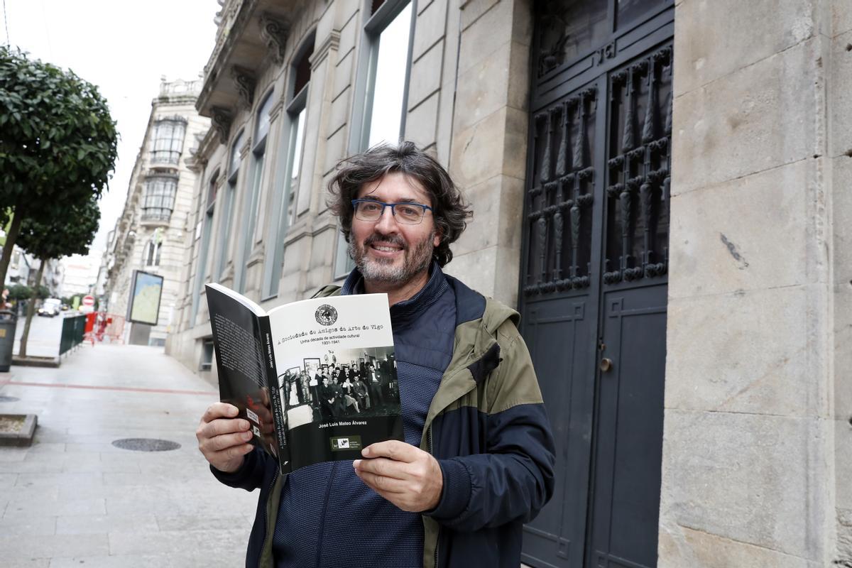 El historiador José Luis Mateo con su libro frente a la puerta de la que en su momento fue sede de la Sociedade Amigos da Arte.