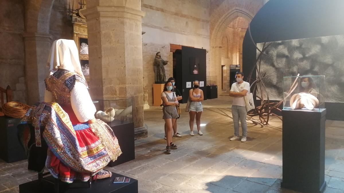 Visitantes admiran algunas de las obras de la exposición en la iglesia del Santo Sepulcro