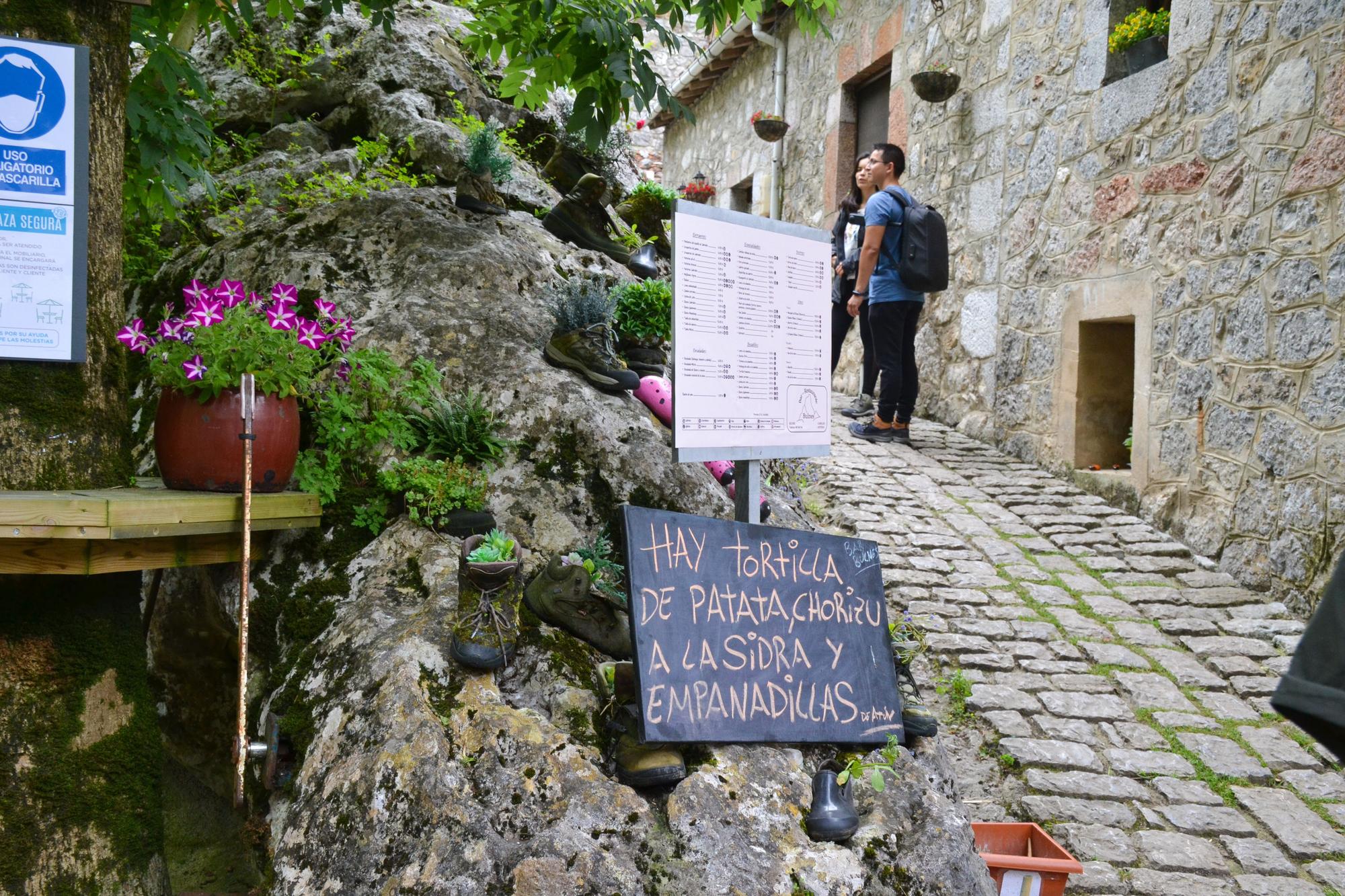 Unos turistas pasan cerca de uno de los establecimientos hosteleros que hay el Bulnes.