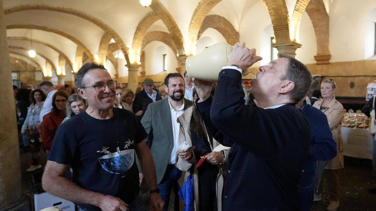 El ministro Luis Planas bebe de un botijo en una feria dentro de Caballerizas Reales, en un acto de campaña.