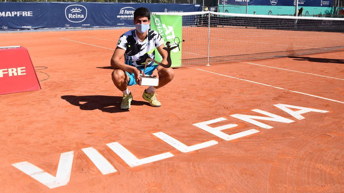 Carlos Alcaraz posa con el  trofeo en la pista.